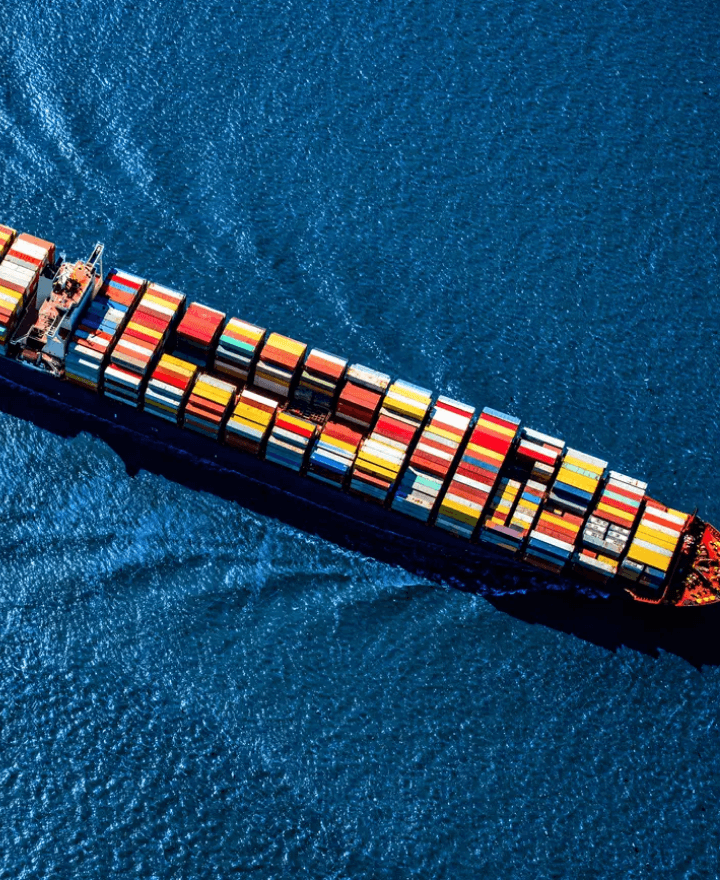 Global sjöfrakt med ett containerfartyg i solnedgång